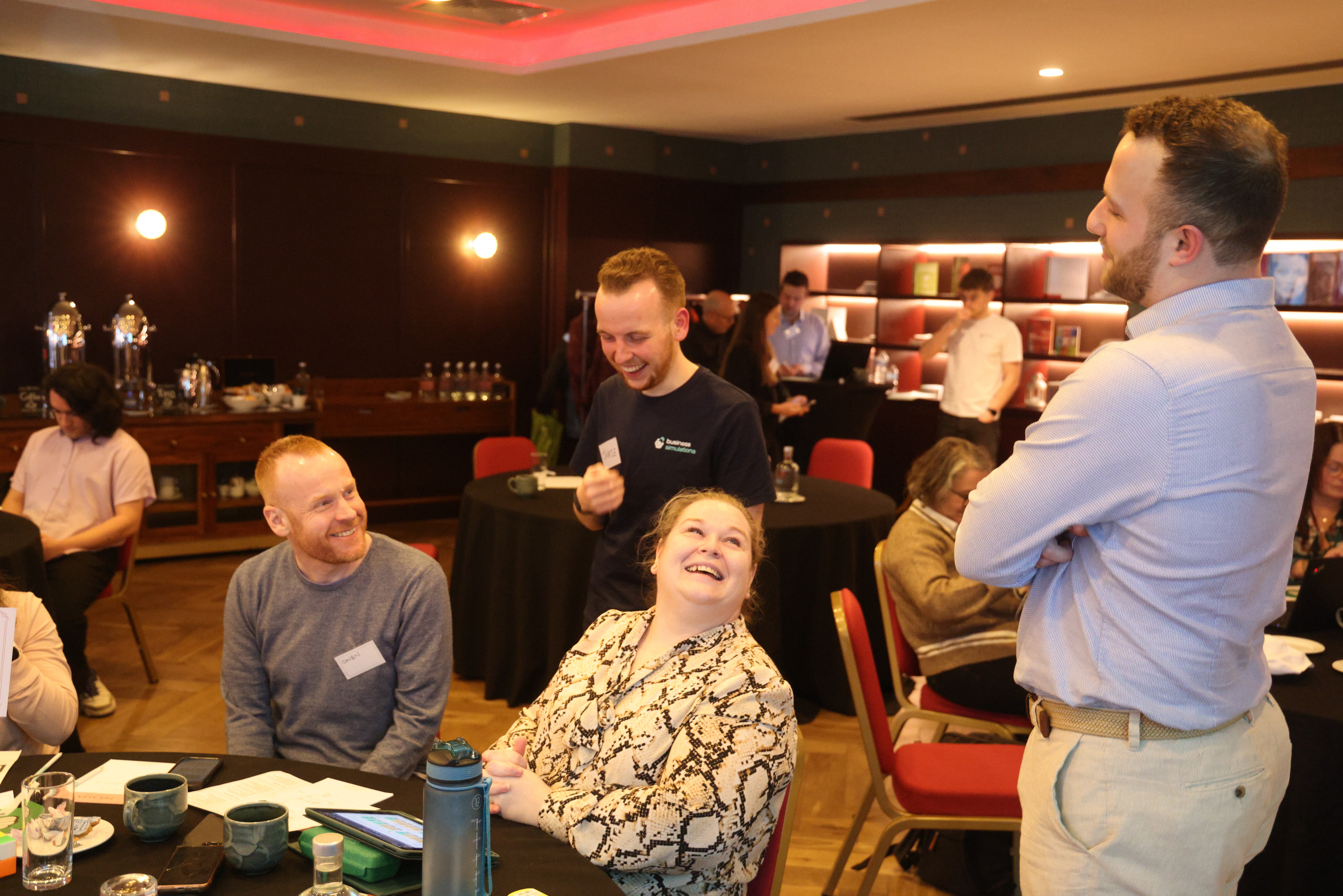 Participants collaborating with a facilitator during a live, in-person business simulation