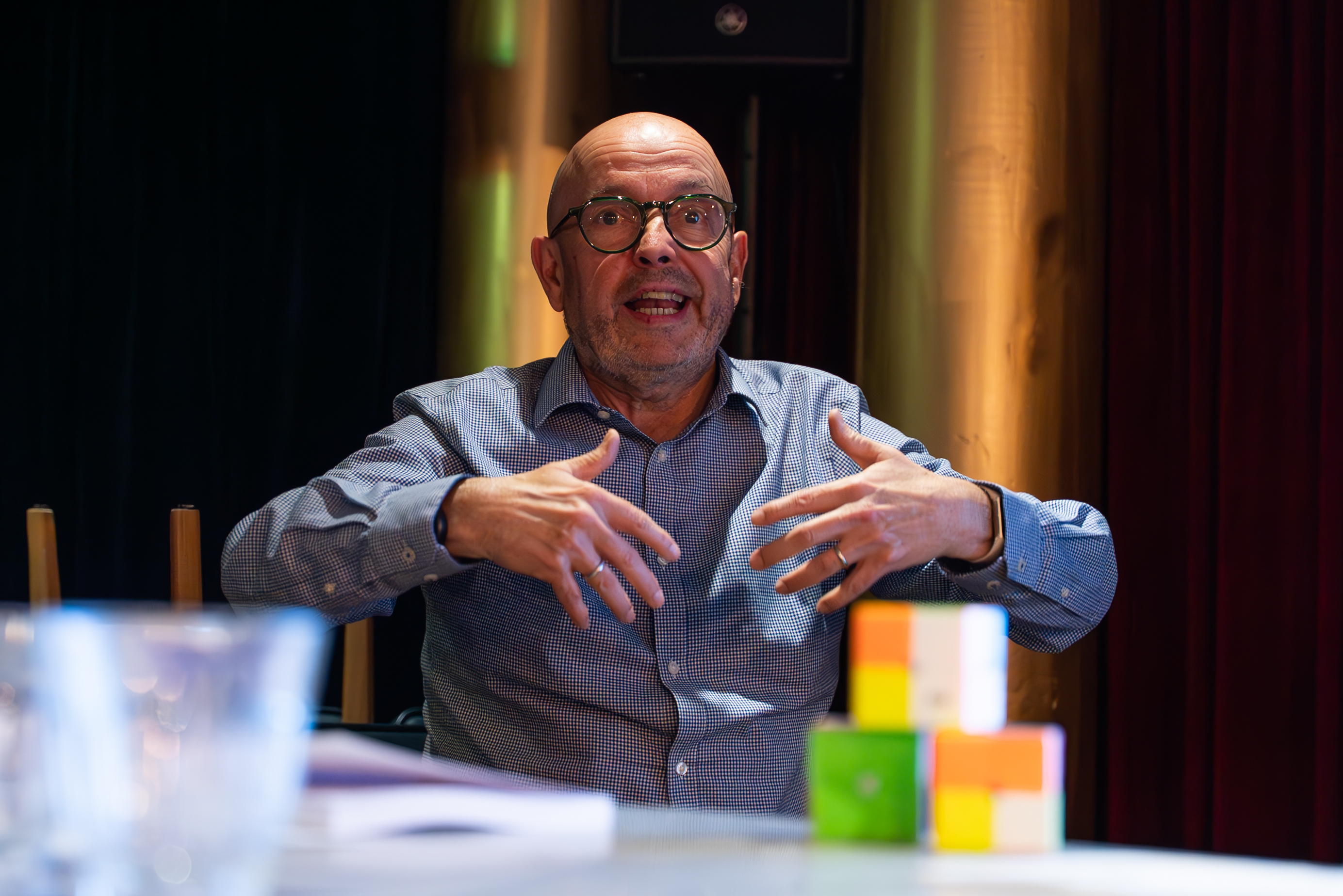A workshop facilitator gesturing expressively while leading a team through a live business simulation