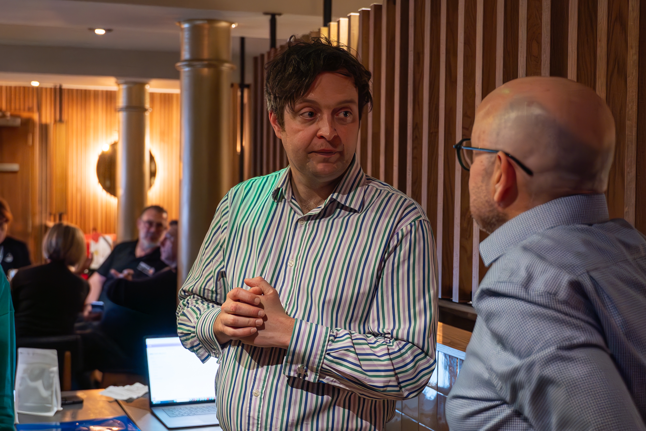 Two colleagues in a one-to-one conversation during a business simulation workshop