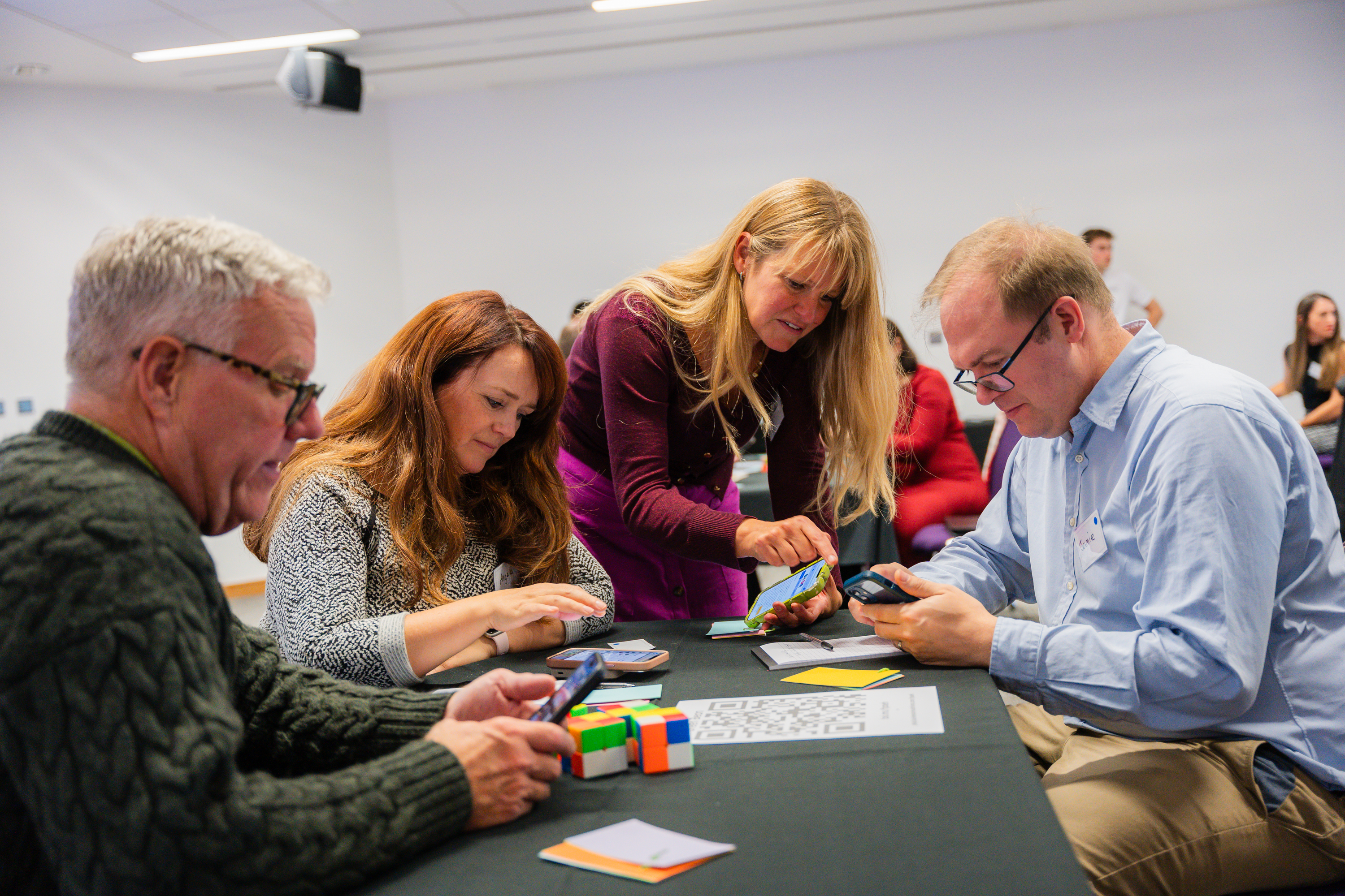 Participants discussing during a simulation, pointing at phones