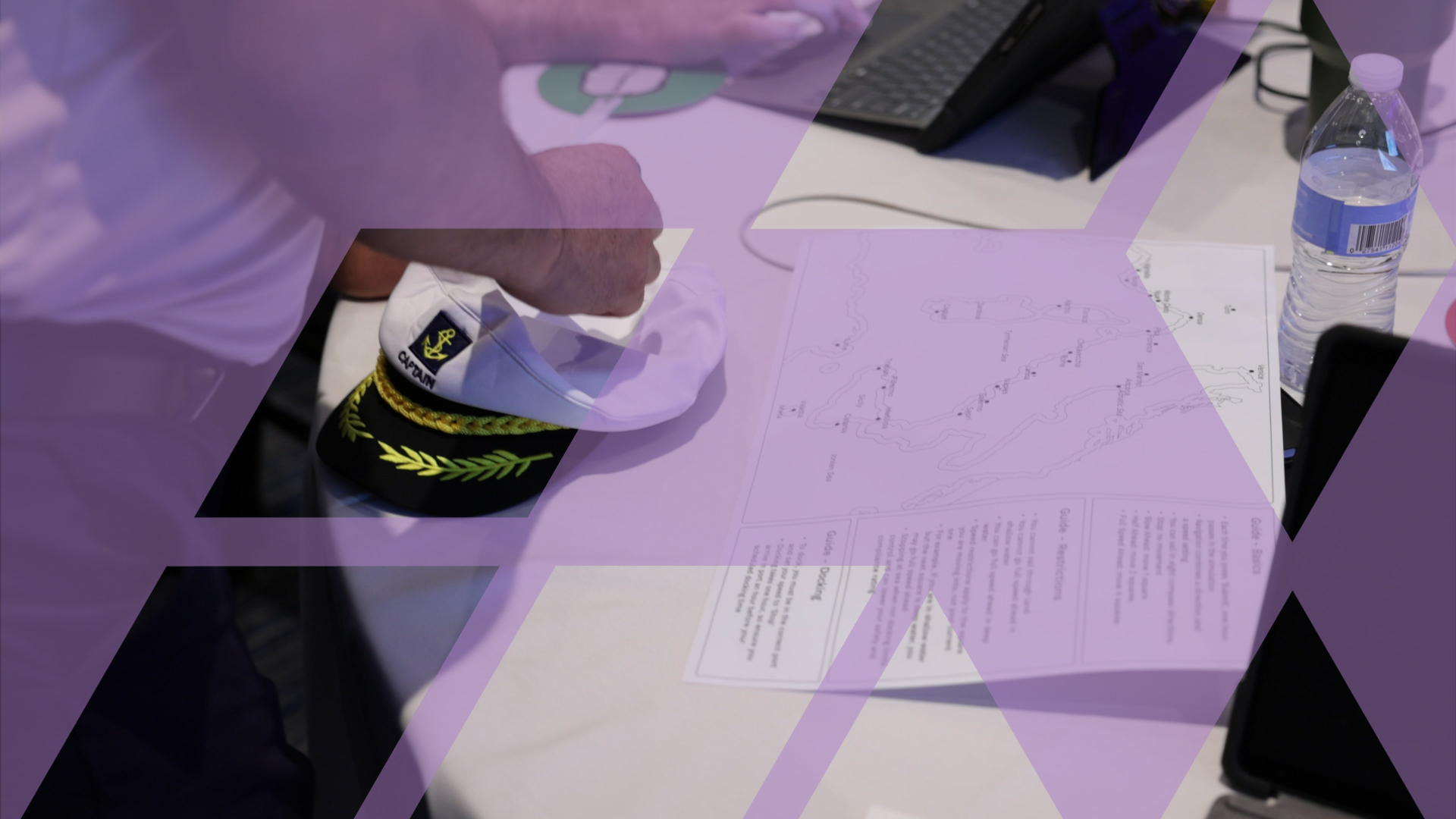 A printed strategy map and simulation materials laid out on a table, with a participant working alongside a laptop.