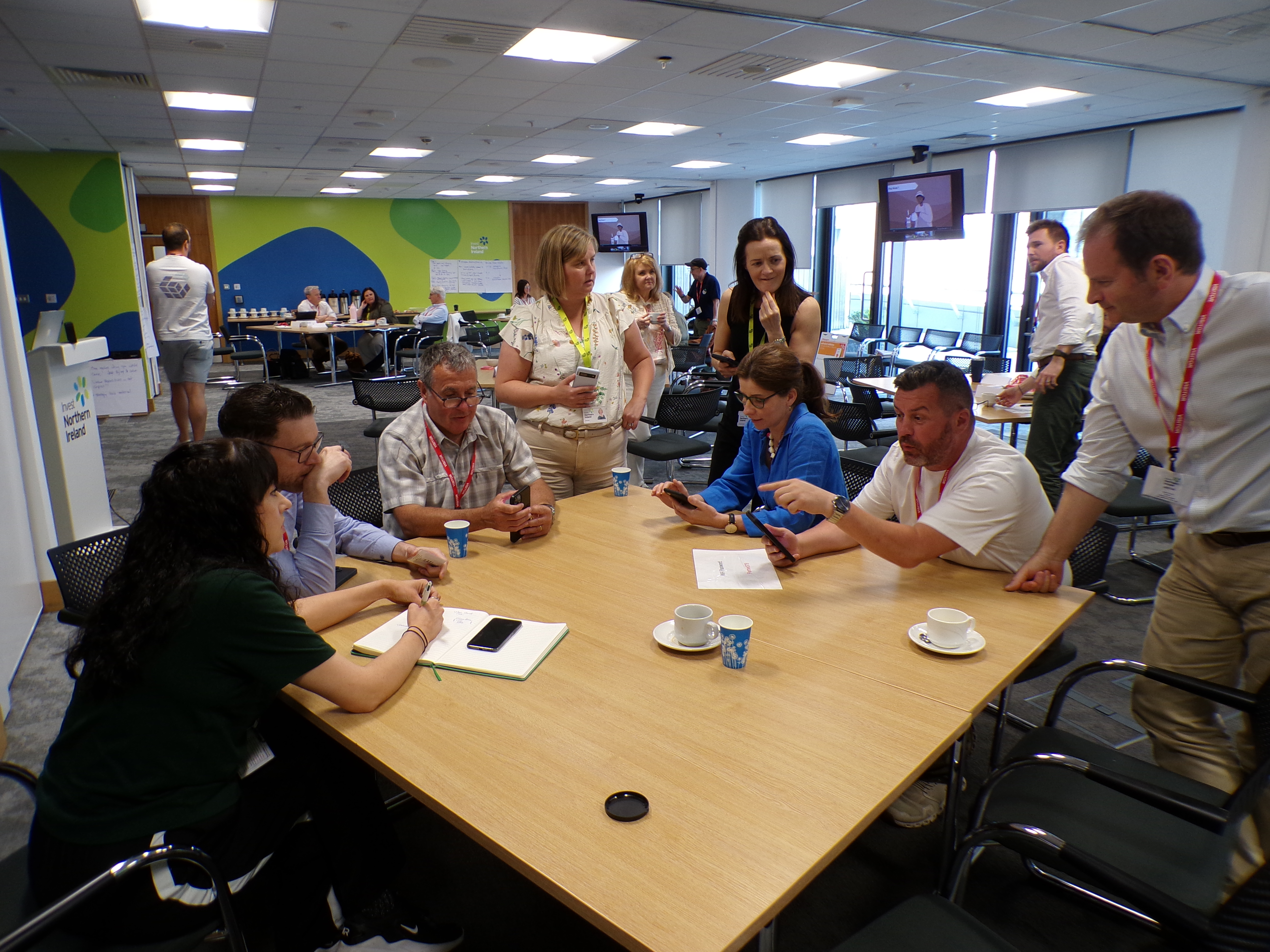 Business team participants seated at table during facilitated simulation exercise in modern office space.