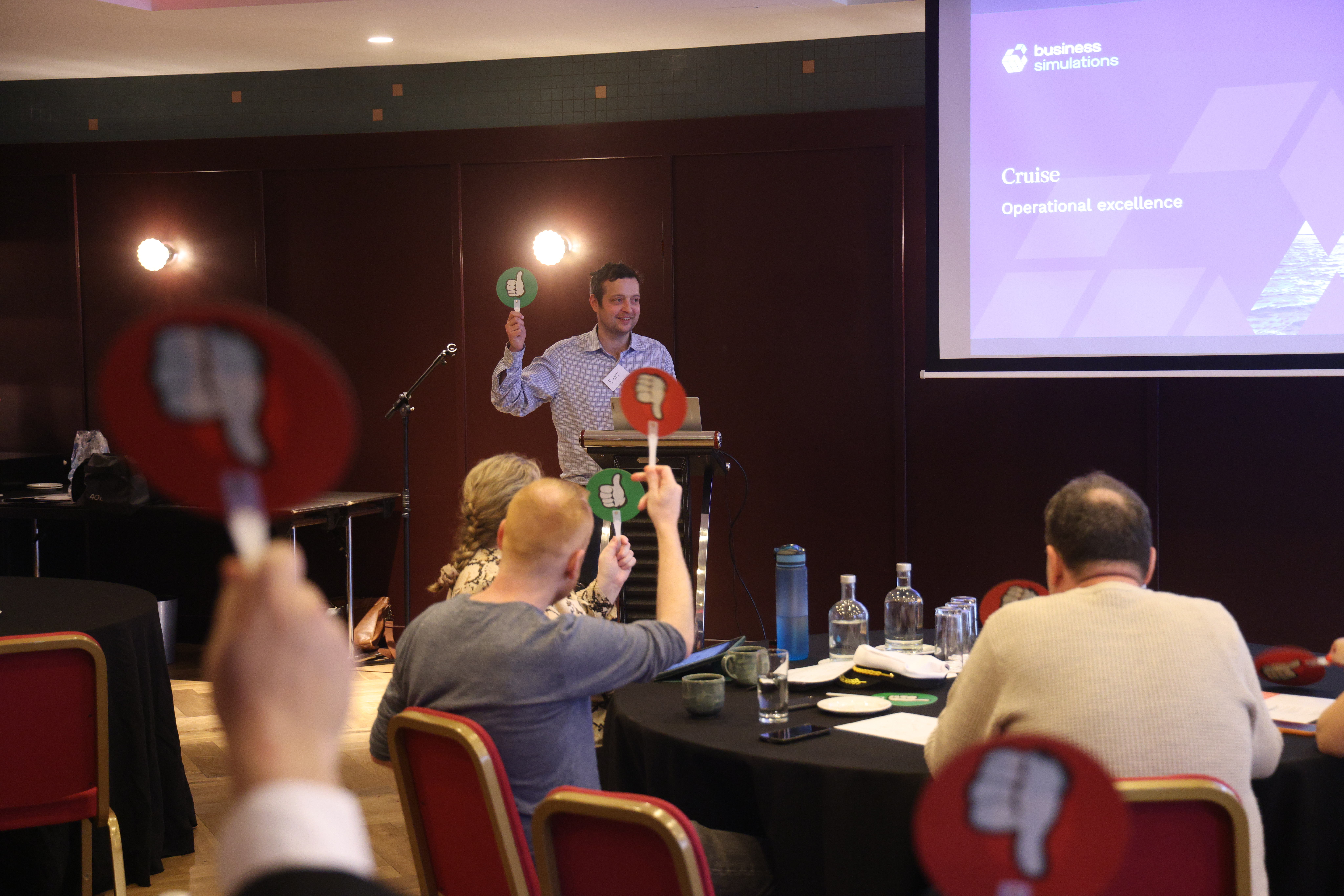 Participants voting during a simulation using thumbs up and thumbs down cards